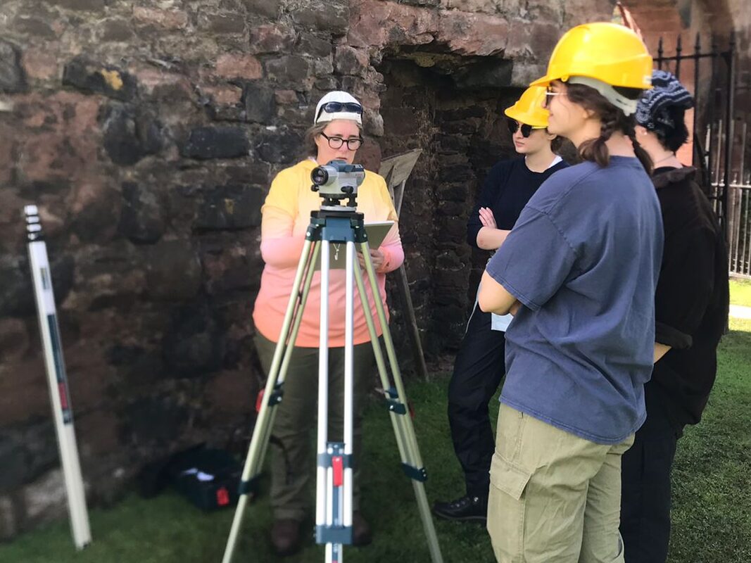 A group of people in high-vis vests surveying a site outside