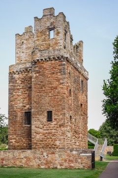 Exterior of a castellated tower built out of rough sandstone.